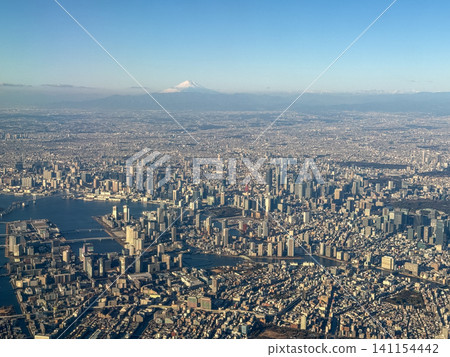 Aerial view of the Tokyo cityscape against a clear blue sky and the magnificent Mount Fuji. Aerial view of the Tokyo cityscape against a clear blue sky and the magnificent Mount Fuji. 141154442