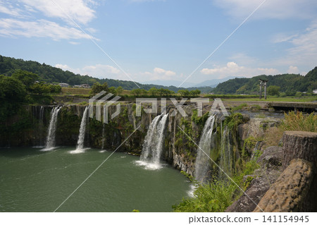 A dynamic waterfall scene against a blue sky. A dynamic waterfall scene against a blue sky. 141154945