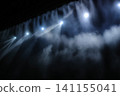 The stage lighting creates a fantastical backdrop with spotlights and smoke. 141155041