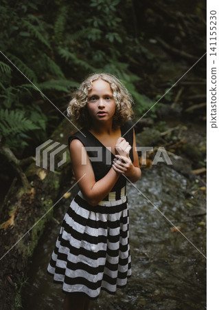 Teenage Girl in Striped Dress in a Forest Setting Teenage Girl in Striped Dress in a Forest Setting 141155230