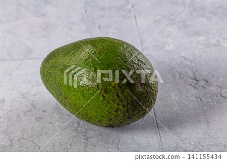 Ripe green avocado on textured gray surface 141155434
