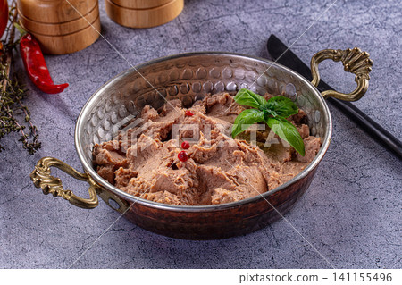 Creamy bean dip in hammered metal bowl with basil and red peppercorns Creamy bean dip in hammered metal bowl with basil and red peppercorns 141155496