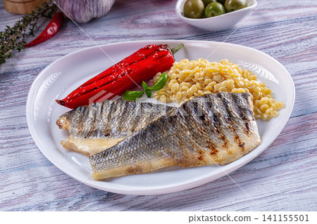 Grilled seabass fillet with roasted red pepper and pearl pasta on white plate Grilled seabass fillet with roasted red pepper and pearl pasta on white plate 141155501