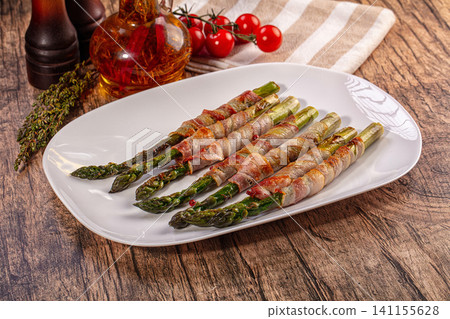 Bacon wrapped asparagus on white plate with cherry tomatoes and herbs Bacon wrapped asparagus on white plate with cherry tomatoes and herbs 141155628