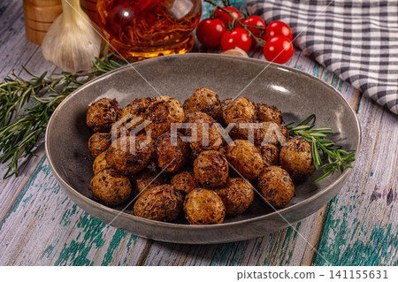 Roasted baby potatoes with rosemary in ceramic bowl on rustic table Roasted baby potatoes with rosemary in ceramic bowl on rustic table 141155631