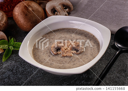 Creamy mushroom soup in white bowl with sliced mushroom garnish and fresh basil Creamy mushroom soup in white bowl with sliced mushroom garnish and fresh basil 141155668