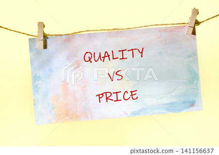 A sign displays the words quality and price connected by a line. The setting is plain, and the focus is on the contrast between the two concepts A sign displays the words quality and price connected by a line. The setting is plain, and the focus is on the contrast between the two concepts 141156637