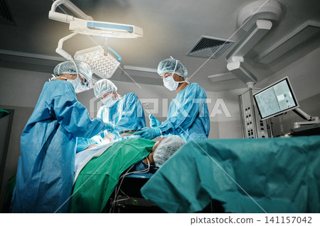 Healthcare, surgery and doctors with patient for emergency medical procedure in theater. Hospital, lights and surgical team for operation on person together in ICU, professional support and help. Healthcare, surgery and doctors with patient for emergency medical procedure in theater. Hospital, lights and surgical team for operation on person together in ICU, professional support and help. 141157042