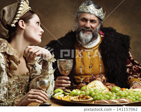 King, queen and royalty with buffet and wine in banquet hall for fine dinning for tradition or culture in palace. Monarch, sovereign and together with feast for luxury, bored and vintage with goblet. King, queen and royalty with buffet and wine in banquet hall for fine dinning for tradition or culture in palace. Monarch, sovereign and together with feast for luxury, bored and vintage with goblet. 141157062
