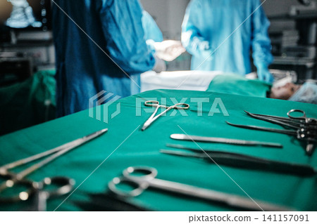 Surgery, medical and equipment on table in hospital for transplant procedure treatment. Healthcare, scissors and surgeons working with metal surgical tools for operation at medicare clinic theater. Surgery, medical and equipment on table in hospital for transplant procedure treatment. Healthcare, scissors and surgeons working with metal surgical tools for operation at medicare clinic theater. 141157091