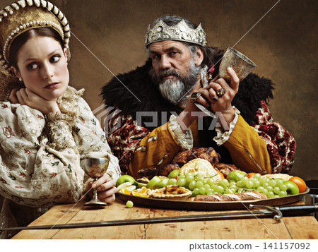 King, queen and portrait with feast at table for fine dinning in royal banquet, vintage and majestic with crown. Monarch, husband and bored together with alcohol for buffet for formal celebration. King, queen and portrait with feast at table for fine dinning in royal banquet, vintage and majestic with crown. Monarch, husband and bored together with alcohol for buffet for formal celebration. 141157092