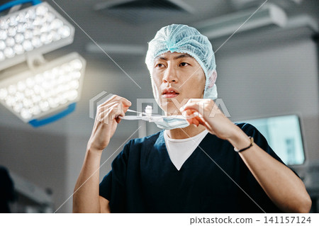 Medical, uniform and doctor in theatre for surgery, safety and preparation for operation in hospital. Asian man, surgeon and clothes with thinking for cardiology procedure, protection and healthcare Medical, uniform and doctor in theatre for surgery, safety and preparation for operation in hospital. Asian man, surgeon and clothes with thinking for cardiology procedure, protection and healthcare 141157124