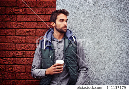 Fashion, wall or man with coffee thinking of casual clothes, style or edgy hoodie for winter outdoor outfit. Tea, cool model or stylish person in urban town in streetwear or trendy jacket in Italy 141157179