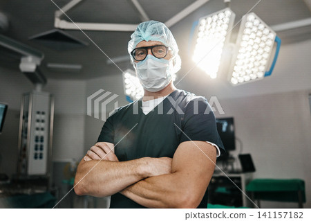 Surgery, portrait and arms crossed by man doctor in operating room with confidence in medical, healthcare or emergency. Hospital, face mask and male surgeon in theatre with pride, help or leadership Surgery, portrait and arms crossed by man doctor in operating room with confidence in medical, healthcare or emergency. Hospital, face mask and male surgeon in theatre with pride, help or leadership 141157182