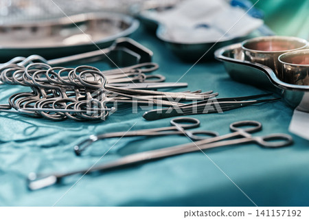 Medical, surgery and steel tools for hospital care in sterile theater with forceps in operating room, clamps or scissors. Equipment, scalpel and table for surgical procedure, healthcare or wellness Medical, surgery and steel tools for hospital care in sterile theater with forceps in operating room, clamps or scissors. Equipment, scalpel and table for surgical procedure, healthcare or wellness 141157192