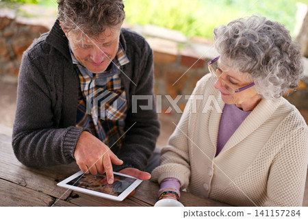 Senior couple, tablet or app to search, internet or contact on social media, blog or relax on patio. Man, woman or touch screen to browse, learn or download of meme, news or ebook on web app for fun Senior couple, tablet or app to search, internet or contact on social media, blog or relax on patio. Man, woman or touch screen to browse, learn or download of meme, news or ebook on web app for fun 141157284