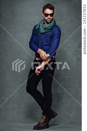 Fashion, confidence and man or model in studio isolated on a gray background mockup space. Serious, person and roll sleeve on shirt for style in casual clothes, trendy or cool sunglasses with jeans Fashion, confidence and man or model in studio isolated on a gray background mockup space. Serious, person and roll sleeve on shirt for style in casual clothes, trendy or cool sunglasses with jeans 141157652