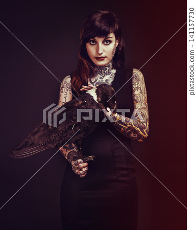 Bird, tattoo or portrait of woman in studio for fashion or edgy style isolated on black background. Pied crow, dark or cool female punk model with ink for unique art, aesthetic or creative expression 141157730