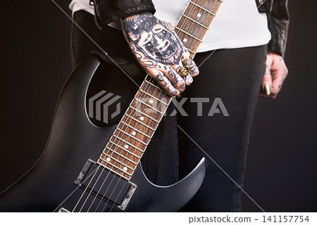 Metal, woman and guitar on black background for punk culture or grunge, edgy and goth fashion with closeup. Rock star, hands and isolated in studio with instrument for band music with dark leather. Metal, woman and guitar on black background for punk culture or grunge, edgy and goth fashion with closeup. Rock star, hands and isolated in studio with instrument for band music with dark leather. 141157754