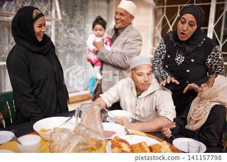 Muslim family, Eid and discussion by table with food for celebration, conversation and eating together. Islamic people, culture and religious holiday with lunch for nutrition, love and special event Muslim family, Eid and discussion by table with food for celebration, conversation and eating together. Islamic people, culture and religious holiday with lunch for nutrition, love and special event 141157798