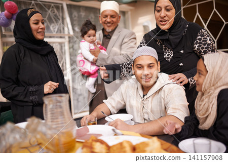Muslim family, Eid and lunch by table with food for celebration, conversation and eating together. Islamic people, culture and religious holiday with meal for special event, love and nutrition Muslim family, Eid and lunch by table with food for celebration, conversation and eating together. Islamic people, culture and religious holiday with meal for special event, love and nutrition 141157908