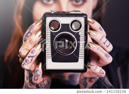Tattoo, portrait or woman with retro camera in studio for hobby, creative photography or memory. Closeup, vintage technology or photographer with ink on hands or picture device on black background 141158138