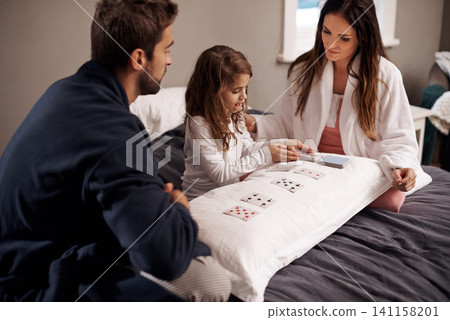 Parents, girl and child with playing cards in bedroom for bonding, learning and relax with love in house. Father, mother and daughter with games, maths and teaching with connection in family home Parents, girl and child with playing cards in bedroom for bonding, learning and relax with love in house. Father, mother and daughter with games, maths and teaching with connection in family home 141158201