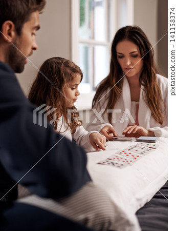 Mom, dad and girl with playing cards in home with bonding, learning and relax with strategy in bedroom. Father, mother and daughter with deal, game and teaching on bed with connection in family house Mom, dad and girl with playing cards in home with bonding, learning and relax with strategy in bedroom. Father, mother and daughter with deal, game and teaching on bed with connection in family house 141158374