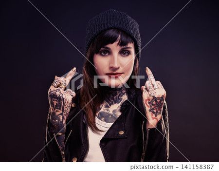 Fashion, portrait woman with middle finger, tattoo or attitude in studio with gothic, style or artistic expression on black background. Rebel, face and emo model with hand, emoji or grunge aesthetic Fashion, portrait woman with middle finger, tattoo or attitude in studio with gothic, style or artistic expression on black background. Rebel, face and emo model with hand, emoji or grunge aesthetic 141158387