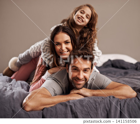 Parents, child and portrait in bedroom to relax in home for weekend break, family time and happiness for bonding. Father, mother and girl comfy or cozy together on Easter Sunday morning for love. Parents, child and portrait in bedroom to relax in home for weekend break, family time and happiness for bonding. Father, mother and girl comfy or cozy together on Easter Sunday morning for love. 141158506