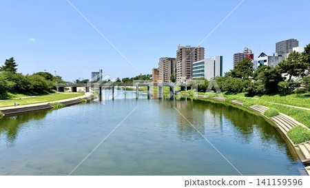 音川沿岸的城鎮風光,以及戶野橋,在初夏的藍天和翠綠的襯托下顯得格外迷人。 (音川河畔綠地(從櫻城橋望去)/愛知縣岡崎市) 音川沿岸的城鎮風光,以及戶野橋,在初夏的藍天和翠綠的襯托下顯得格外迷人。 (音川河畔綠地(從櫻城橋望去)/愛知縣岡崎市) 141159596