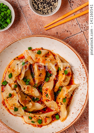 Dumplings with spicy sauce served on a plate Dumplings with spicy sauce served on a plate 141160541