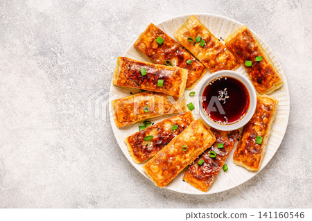 Dumplings are arranged on a plate with a small bowl of dipping sauce Dumplings are arranged on a plate with a small bowl of dipping sauce 141160546