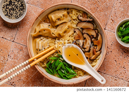 Delicious bowl of noodles with dumplings and mushrooms Delicious bowl of noodles with dumplings and mushrooms 141160672