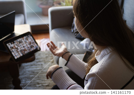 Frustrated young woman participating in a video call, feeling stressed and tired during remote work, balancing concentration and emotional strain while meeting deadlines 141161170