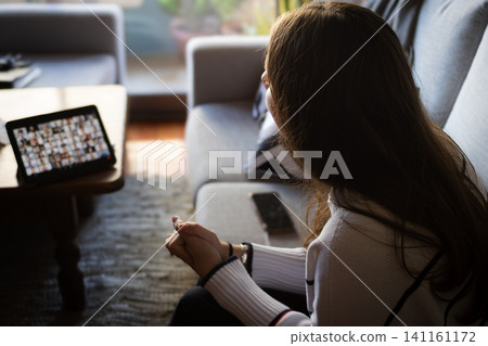 Woman working remotely from home, attending an exhausting virtual team meeting or educational video conference, feeling stressed, tired, and frustrated by communication challenges Woman working remotely from home, attending an exhausting virtual team meeting or educational video conference, feeling stressed, tired, and frustrated by communication challenges 141161172