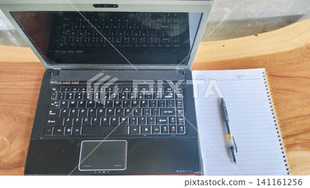 Open Laptop Computer with Spiral Notebook and Pen on Wooden Table Open Laptop Computer with Spiral Notebook and Pen on Wooden Table 141161256