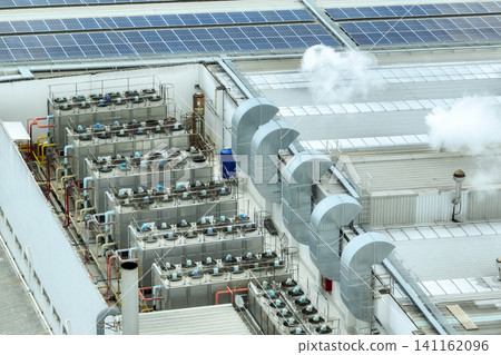 Sustainable industrial rooftop. Aerial view showcasing solar panels, ventilation systems, and industrial chillers. Renewable energy and efficient cooling in modern manufacturing facilities. Sustainable industrial rooftop. Aerial view showcasing solar panels, ventilation systems, and industrial chillers. Renewable energy and efficient cooling in modern manufacturing facilities. 141162096