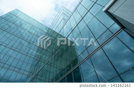 Modern sustainable glass office building. Exterior view of corporate headquarters glass building architecture. Energy-efficient building. Financial business center tower. Glass windows of company. Modern sustainable glass office building. Exterior view of corporate headquarters glass building architecture. Energy-efficient building. Financial business center tower. Glass windows of company. 141162161