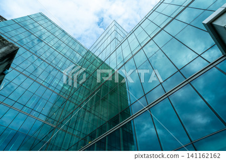 Modern sustainable green glass office building. Exterior view of corporate headquarters glass building architecture. Energy-efficient building. Financial business center. Glass windows of company. Modern sustainable green glass office building. Exterior view of corporate headquarters glass building architecture. Energy-efficient building. Financial business center. Glass windows of company. 141162162