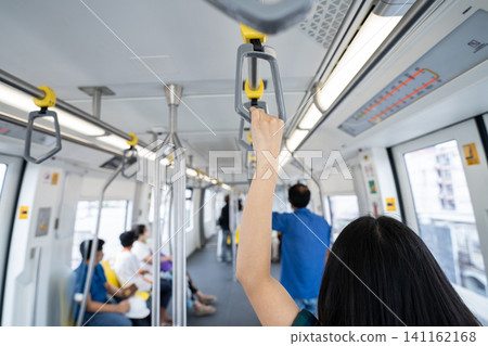 Woman hand firm grip safety handrail in elevated monorail train. Mass transit system in modern city. Inside of electric train. Tourist travel by city sky train. Public transportation. Urban transport. 141162168