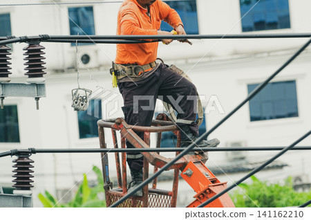 High voltage power line maintenance. Electrician at work. Electrical technician repairing cable wire. High voltage power line construction. Danger of wiring and electrical wires. Work with safety. 141162210