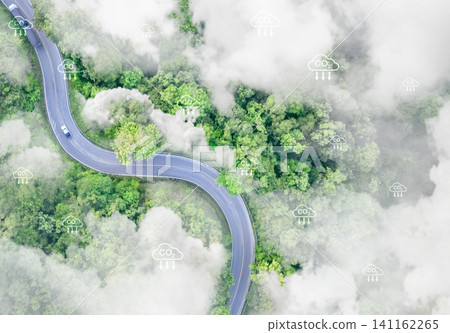 Sustainable transport and natural carbon sink. Aerial view of electric vehicles on highway through lush green forest. Zero-emission mobility and environmental conservation for reduced carbon emissions Sustainable transport and natural carbon sink. Aerial view of electric vehicles on highway through lush green forest. Zero-emission mobility and environmental conservation for reduced carbon emissions 141162265