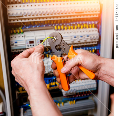 The man is repairing the switchboard voltage with automatic switches. The man is repairing the switchboard voltage with automatic switches. 141162328