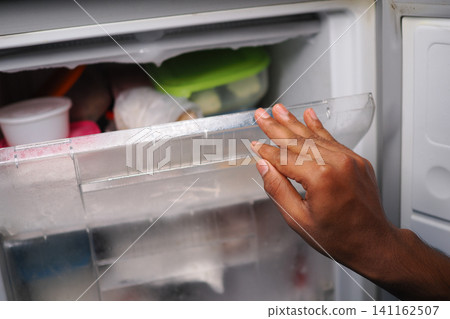 Opening a freezer door to check on food storage Opening a freezer door to check on food storage 141162507