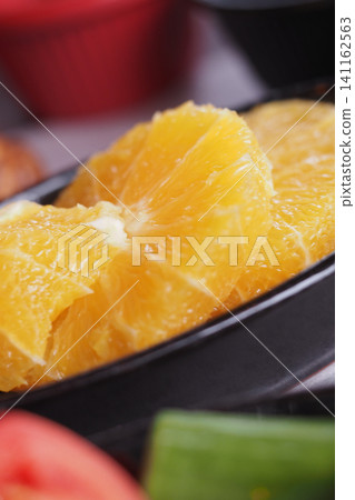 Fresh orange slices on a black plate ready for serving 141162563