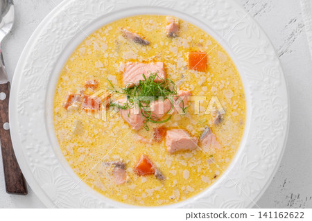 Finnish creamy salmon soup lohikeitto with vegetables served in elegant white plate 141162622