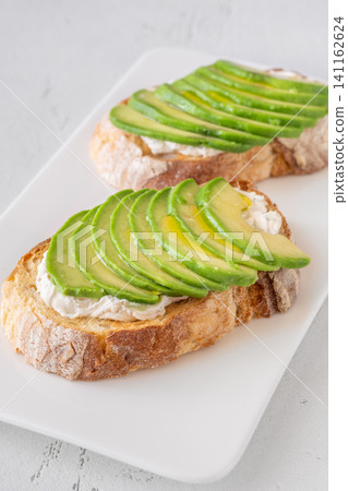 Avocado toast sandwiches with soft cheese on artisan bread fresh healthy meal Avocado toast sandwiches with soft cheese on artisan bread fresh healthy meal 141162624