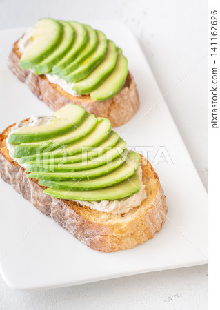 Avocado toast sandwiches with soft cheese on artisan bread fresh healthy meal Avocado toast sandwiches with soft cheese on artisan bread fresh healthy meal 141162626