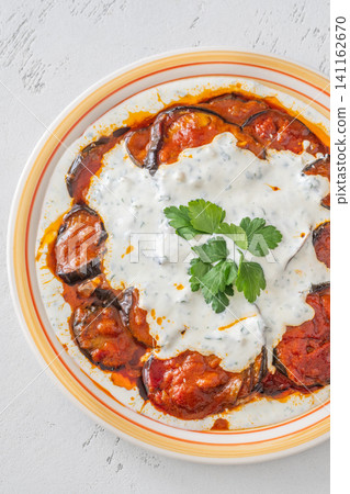 Burani Bonjan Afghan eggplant dish with yogurt garlic sauce and parsley garnish 141162670